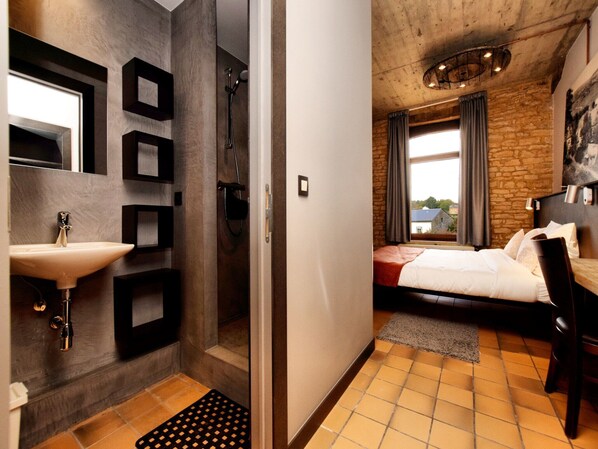 Une chambre d’hôtel moderne, dotée d’une salle de bain, d’un lit et offrant une vue sur l’extérieur.