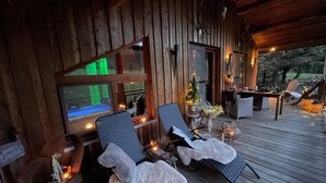 Eine Holzterrasse mit Liegestühlen, einem kleinen Tisch und einem Weihnachtsbaum.
