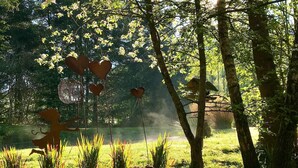 Ein Garten mit herzförmigen Dekorationen, einem Kiesweg und einem Vogelhaus.