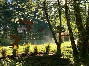 A garden with heart-shaped decorations, a stone pathway, and a birdhouse.