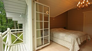 A bedroom with a large window, a wooden deck, and a chandelier. - Countryside Chalet in 	Bomal sur Ourthe with Sauna, Balcony (Bomal sur Ourthe)