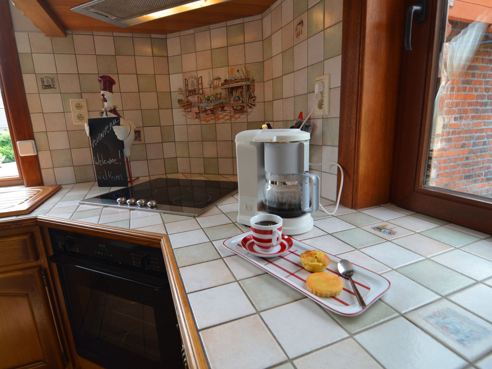 Eine Küche mit Kaffeemaschine, Toaster und einem Tablett mit Muffins.