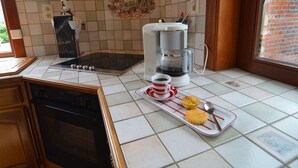 Une cuisine équipée d’une machine à café, d’un grille-pain et d’un plateau de muffins.