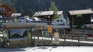 A parking area with a bus stop and directional signs.