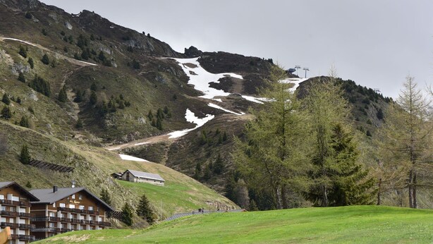 A mountain lodge with a ski slope, a wooden deck, and a building with a sign that reads "Hotel".