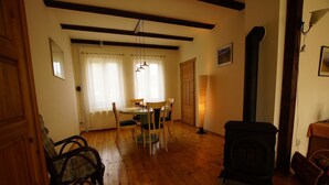 A dining area with a wooden table and chairs, a standing lamp, and a fireplace.