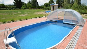 Une piscine extérieure dotée d’un plongeoir et d’un espace abrité.