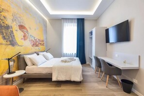 Ein modernes Hotelzimmer mit einem großen Bett, einem Schreibtisch, einem Flachbildfernseher und einem großen, abstrakten Gemälde an der Wand.