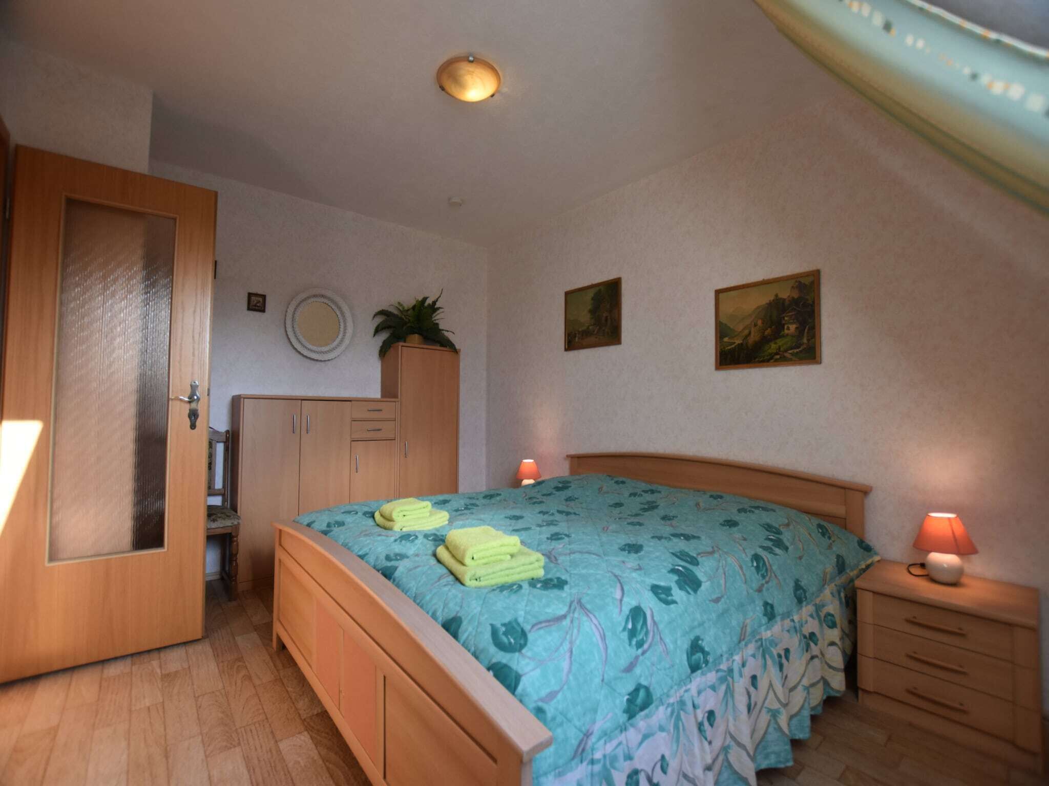 Ein Schlafzimmer mit einem hölzernen Bett, Nachttischlampen, einem Kleiderschrank und einer Deckenleuchte.