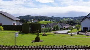 Um bairro residencial com casas, gramado bem cuidado e vista distante de colinas.