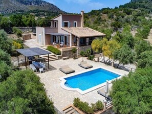 Enjoy a relaxing stay in this two-story house with a spacious patio featuring a pool, seating area, and sun lounger.