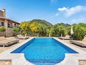 Relax by the pool surrounded by lush greenery and a mountain view.