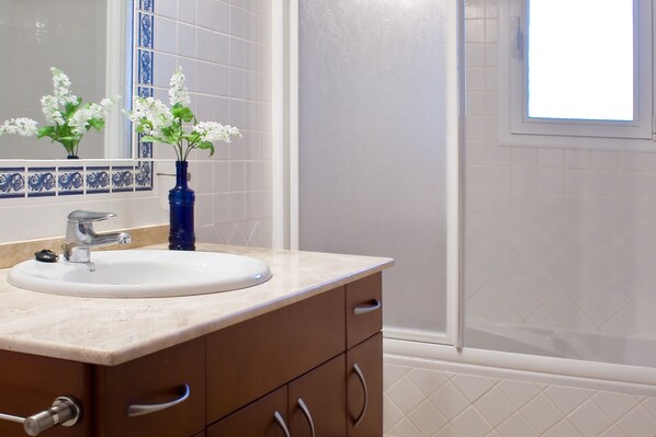 Un baño con lavabo, espejo y ventana.