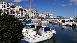 A marina with boats docked, surrounded by multi-story buildings with balconies. - Belvilla by OYO Vistalmar (Manilva, Malaga)
