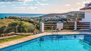 A swimming pool with a view of a coastal town and hills in the background. - Belvilla by OYO Vistalmar (Manilva, Malaga)