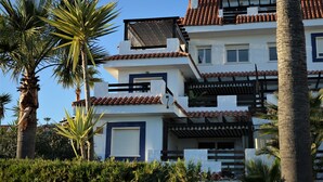A multi-story building with a tiled roof, balconies, and a mix of white and dark blue walls. - Belvilla by OYO Vistalmar (Manilva, Malaga)
