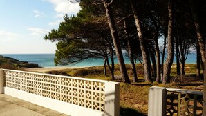 A coastal view with a white lattice fence, trees, and a clear sky. - Villa in Vilamoura near Golf & Beach (Sanxenxo)