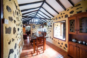 Una cocina rústica con paredes de piedra, vigas de madera y suelo de baldosas.