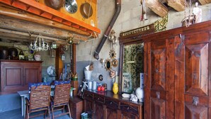 A rustic interior with wooden furniture, a variety of decorative items, and a collection of shoes lined up against the wall.