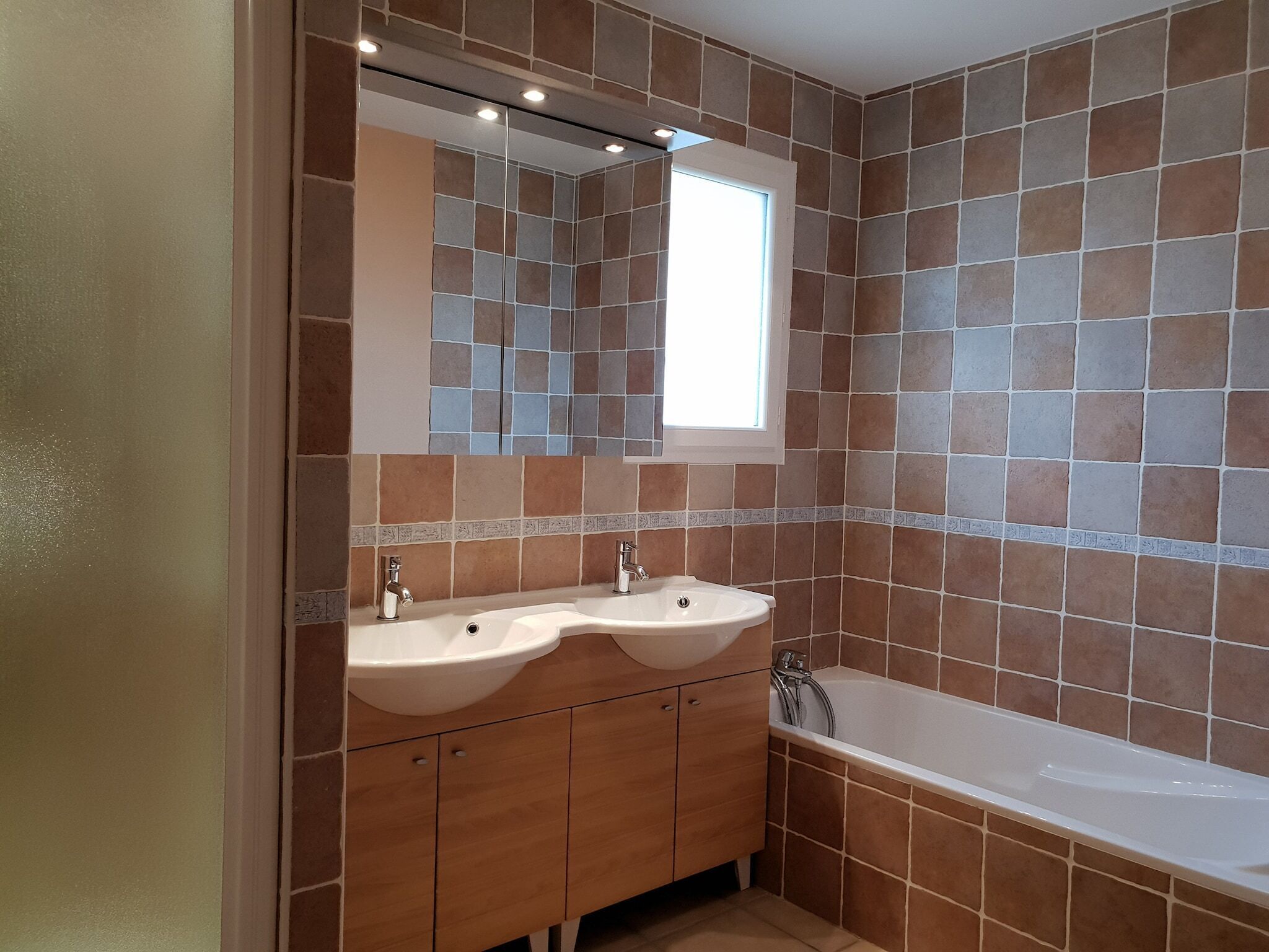 Un bagno con due lavandini, uno specchio e una vasca.