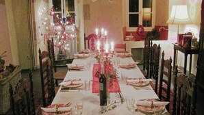 Ein Esszimmer mit einem langen Tisch, der für eine Mahlzeit gedeckt ist, umgeben von Stühlen.