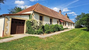 Una casa de dos pisos con techo de tejas, una puerta de madera y un pequeño porche.