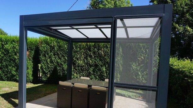 Un patio abrité avec une table et des chaises.