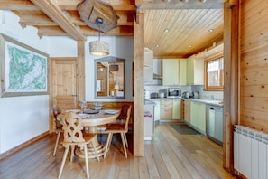 Un intérieur en bois comprenant un coin repas, une cuisine et une grande carte accrochée au mur.