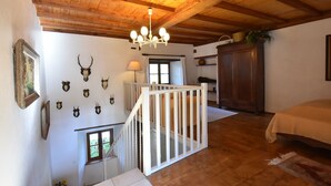 A wooden-floored room with a staircase, a chandelier, and wall-mounted animal heads. - Saint-Sauveur Hideaway (St Sauveur Lendelin)