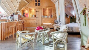Ein gemütliches, rustikales Holzhaus mit Schlafzimmer im Obergeschoss, Essbereich und Küche.