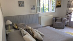 A bedroom with two beds, a chair, a lamp, and a radiator. - Holiday Home in Piolenc near Roman Orange (Piolenc)