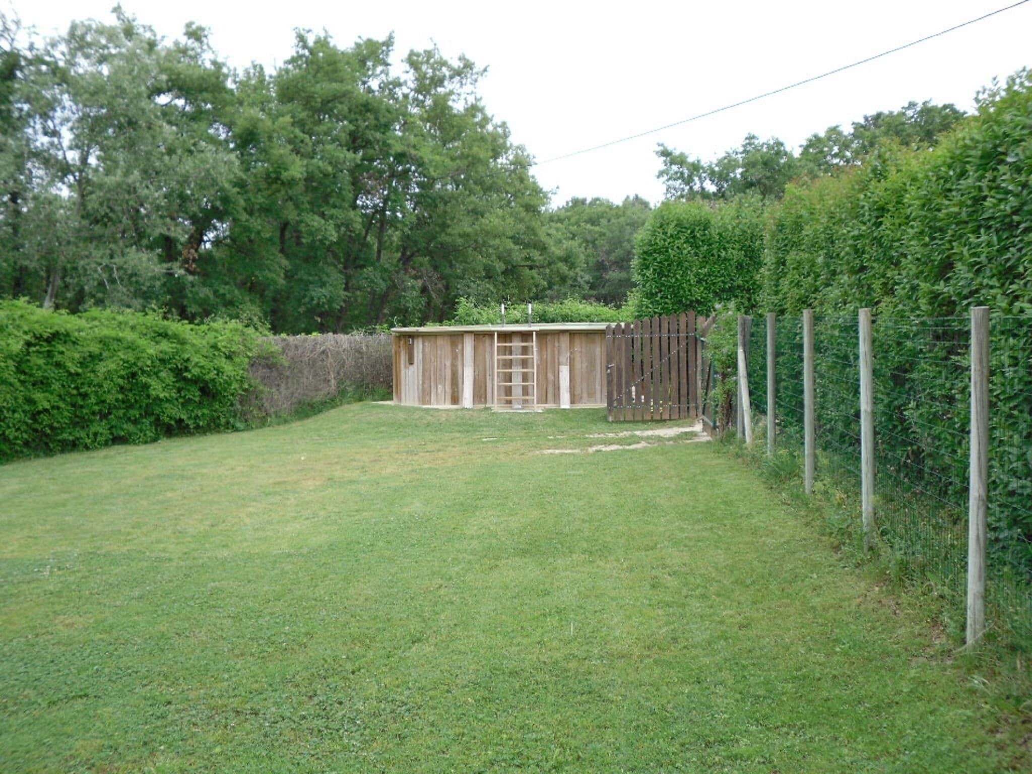 A fenced backyard with a wooden shed, a ladder, and a wooden fence.