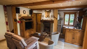 A cozy living room with a fireplace, a television, and a sofa. - Chalet in Ventron near Ski Lift (Ventron)