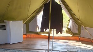 Interno di una tenda con termosifone, un tappeto e un oggetto appeso.