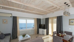 A modern living room with a TV, dining table, and sofas. - Villa in Samos near Aghia Paraskevi Beach (Aghia Paraskevi)