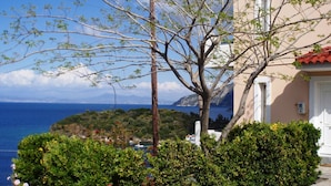 A coastal building with a view of the sea and a tree in the foreground. - Villa in Samos near Aghia Paraskevi Beach (Aghia Paraskevi)