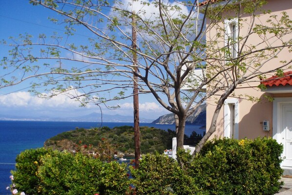 A coastal building with a view of the sea and a tree in the foreground.