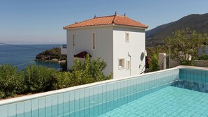 A white building with a red-tiled roof, a swimming pool, and a view of the sea and mountains. - Villa in Samos near Aghia Paraskevi Beach (Aghia Paraskevi)