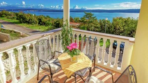 A balcony with a table, chairs, and a potted plant. - Holiday Home in Croatia near Scenic Beach (Dramalj)