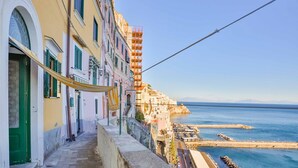 Una calle estrecha con edificios a un lado y un muelle al otro.