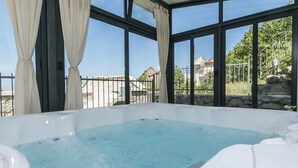 Ein Whirlpool mit freiem Blick auf die Umgebung durch große Fenster.
