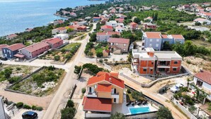 Un quartier résidentiel situé sur la côte, avec des maisons, une piscine et une vue sur la mer.