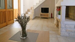 A modern interior with a staircase, a fireplace, and a television on a stand. - Holiday Home in Lumbarda with Garden (Lumbarda)