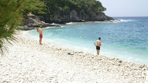 A beach with rocky terrain and a cliff in the background. - Coastal apartment in Vis near sea (Vis)