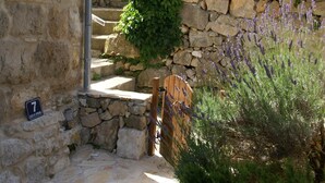 A stone staircase leading up to a wooden door, with a sign indicating the number 7. - Coastal apartment in Vis near sea (Vis)