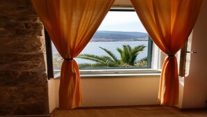 A room with a window overlooking a body of water and palm trees. - Coastal apartment in Vis near sea (Vis)