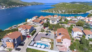 Un quartier résidentiel situé sur la côte, avec des maisons, une piscine et une vue sur la mer.