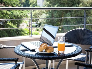 Guests can enjoy a quiet breakfast on the balcony overlooking the lush surroundings.