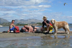 A beach scene with people and a dog. - Cozy villa in Ploce with shared pool (Ploce)