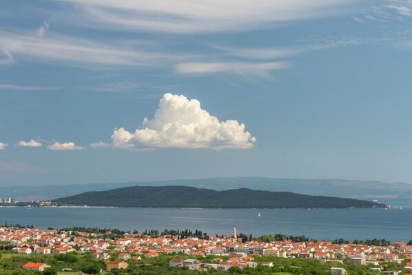 A coastal town with red-roofed buildings, a large body of water, and a mountain in the background. - Modern Stay in Kaštel Stari (Kastel Stari)